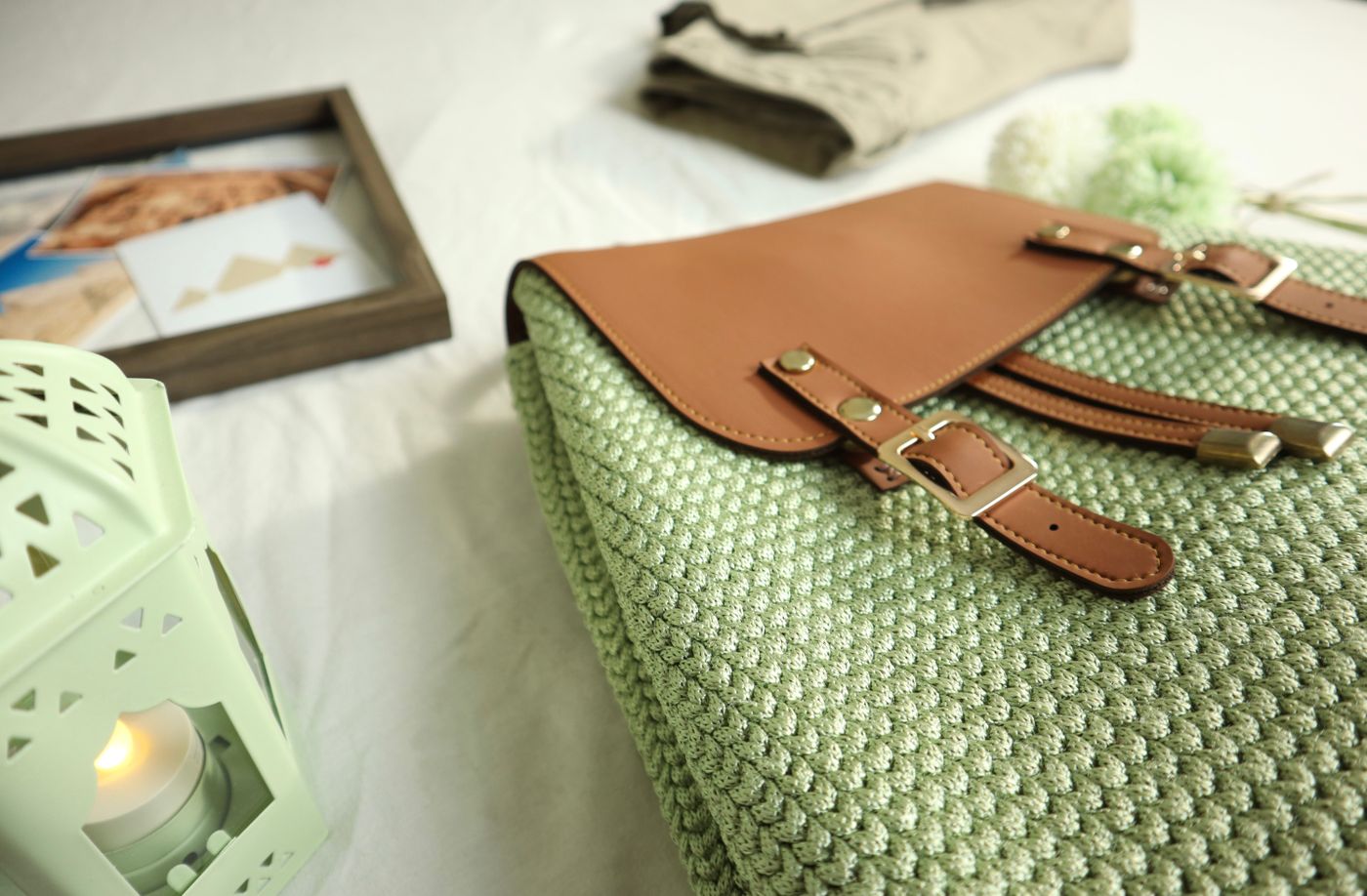 Grüne gehäkelte Tasche mit braunen Lederriemen