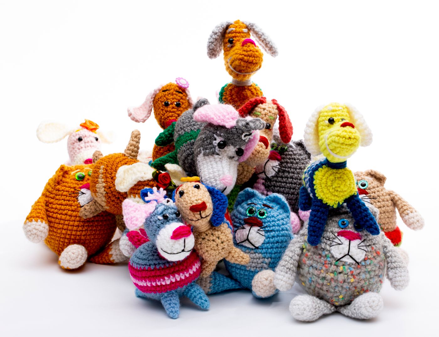 Gruppe bunter gehäkelter Amigurumi-Tiere auf weißem Hintergrund