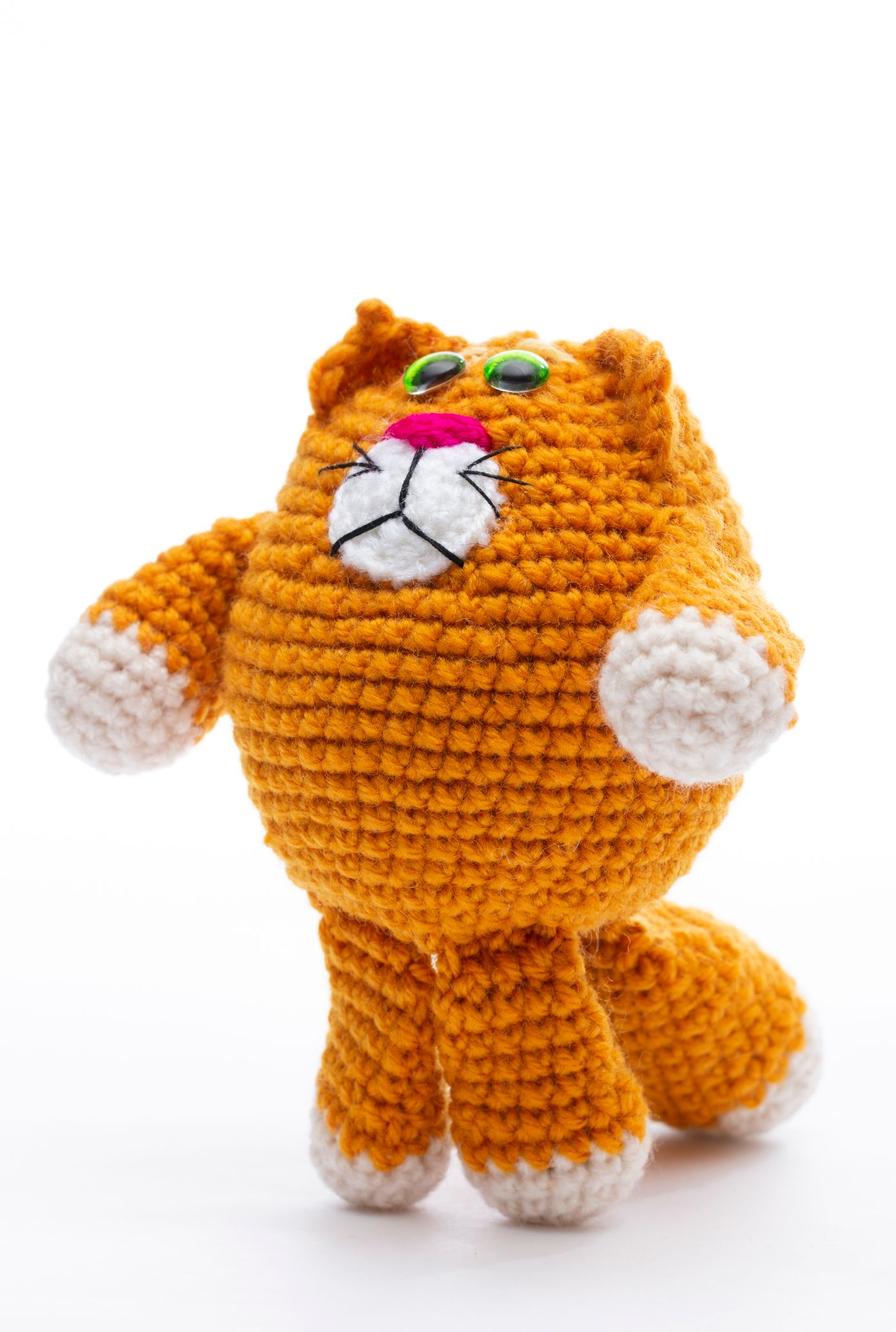 Orange gehäkelte Amigurumi-Katze auf weißem Hintergrund