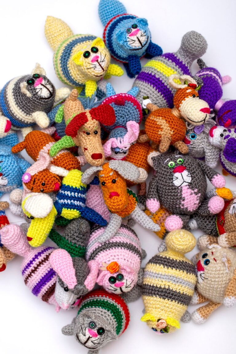 Bunte gehäkelte Amigurumi-Tiere auf weißem Hintergrund